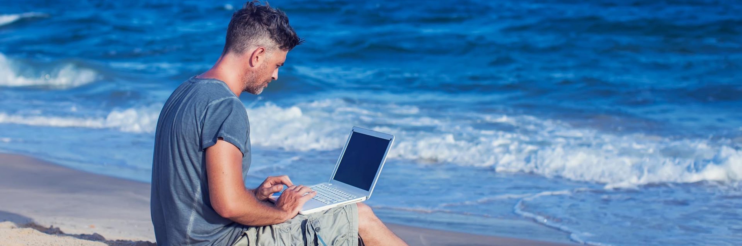 BRW | Zielgruppenseiten Firmenkunden | Mann arbeitet mit dem Laptop am Strand 