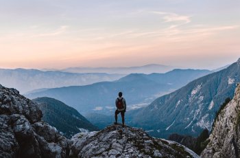 BRW | Privatlösung | Reise & Freizeitversicherung | Ein Mann genießt die Aussicht auf den Gebirgen
